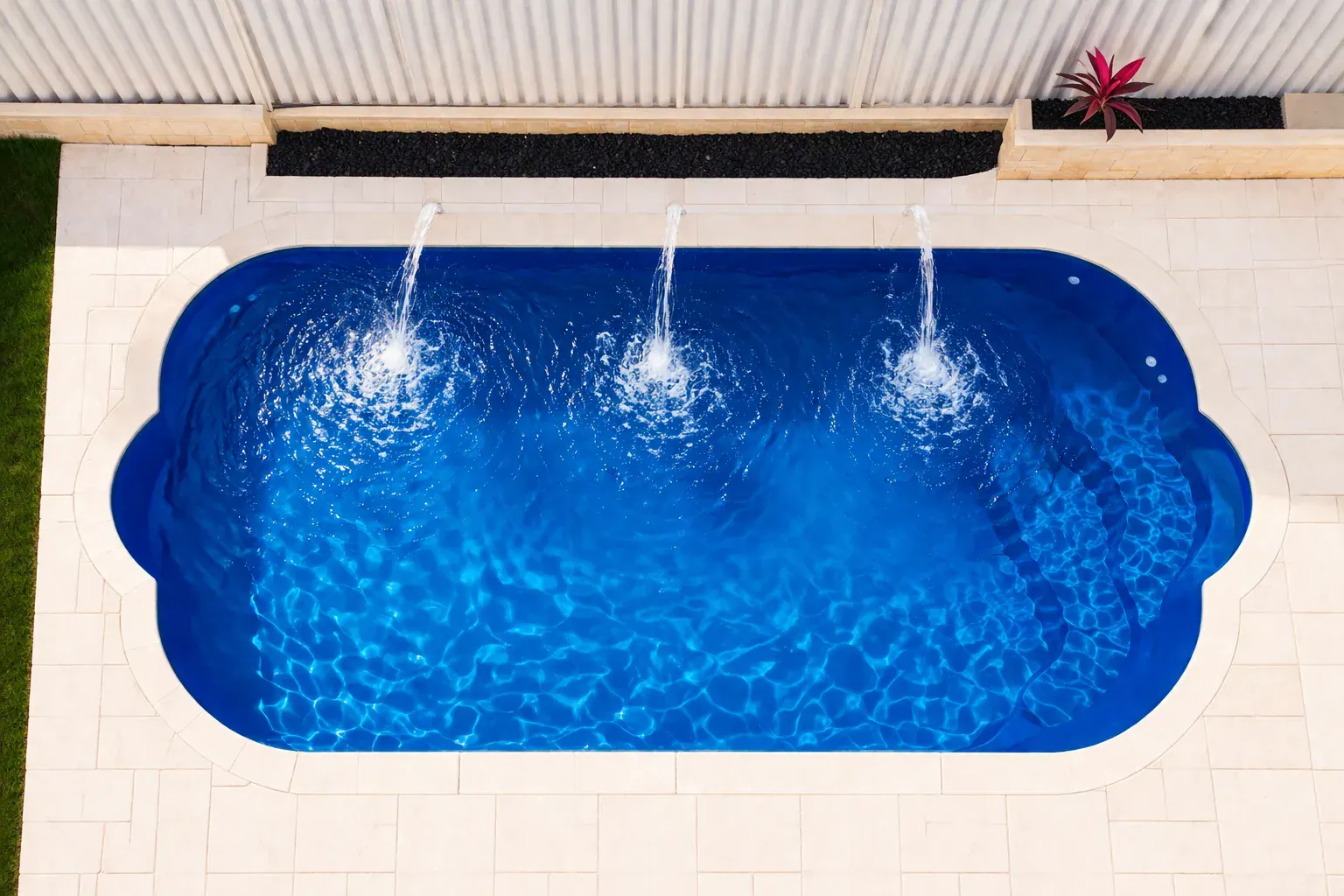 Modern fibreglass swimming pool with clear blue water